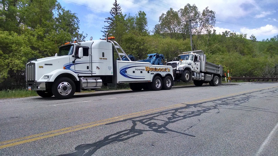 white dumptruck being towed