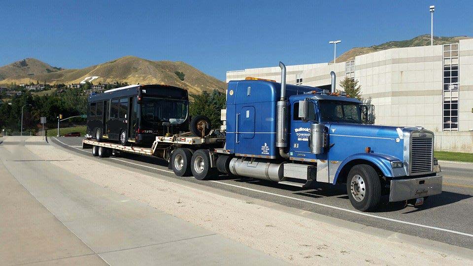 transporting heavy equipment like ablack bus trailering